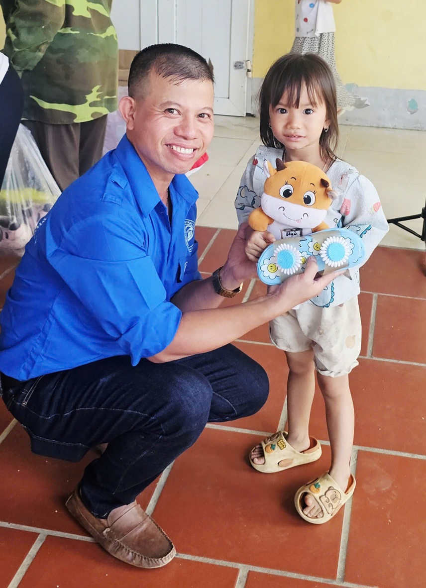 Ảnh 2: Ảnh anh Sơn tặng quà cho một em bé(Nguồn: NVCC)