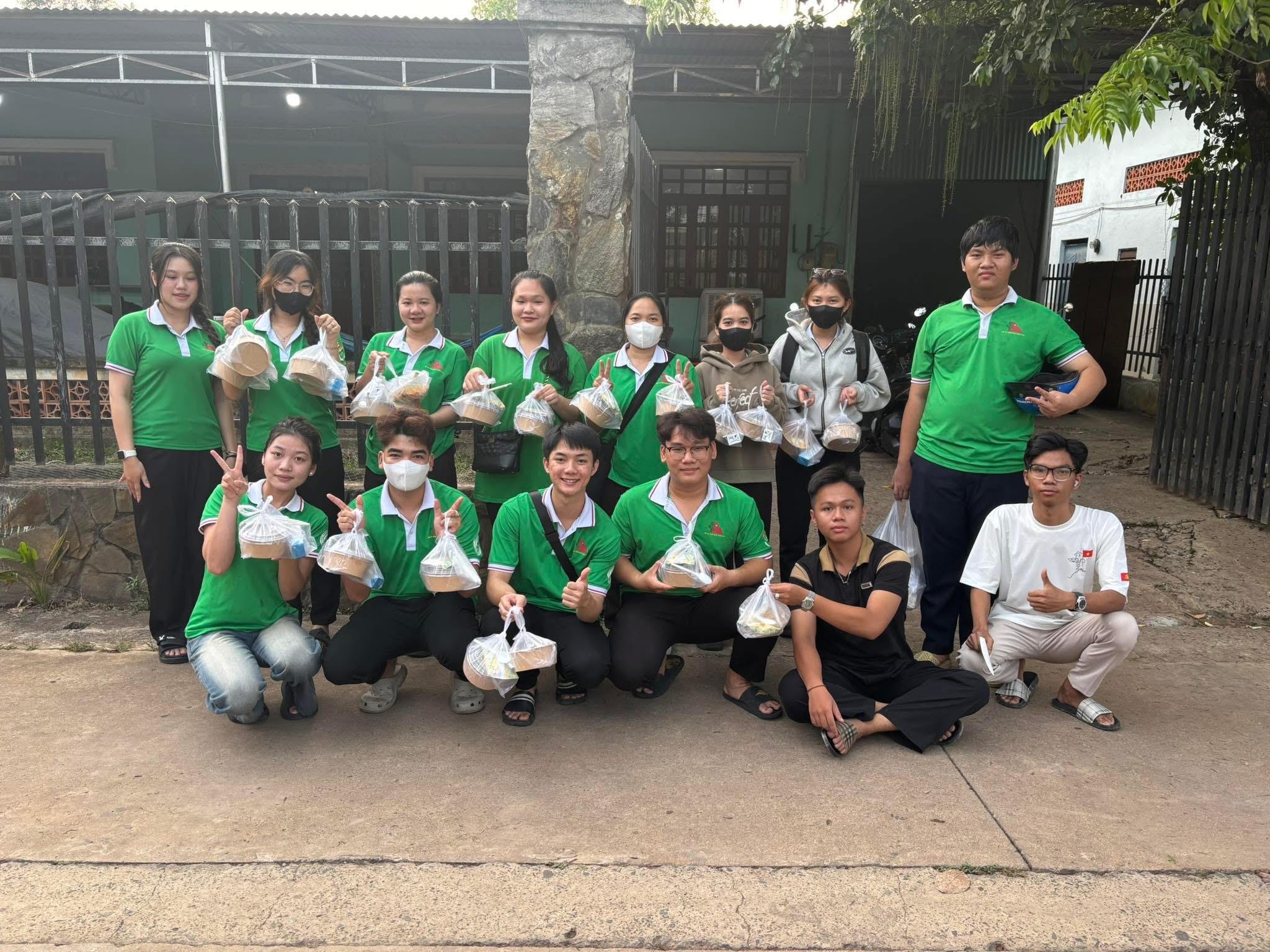 Ảnh 3. Ngọc Phương (ngồi ngoài cùng bên trái) cùng các thành viên trong CLB trao cơm cho những người có hoàn cảnh khó khăn (Ảnh: NVCC)