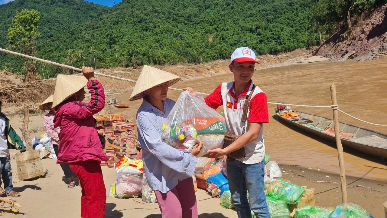 Ảnh 4: Anh Phạm Quang Toản trao phần quà yêu thương đến bà con vùng lũ (Ảnh: NVCC)